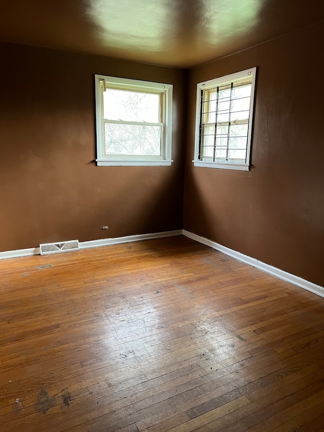 unfurnished room with a wealth of natural light and wood-type flooring