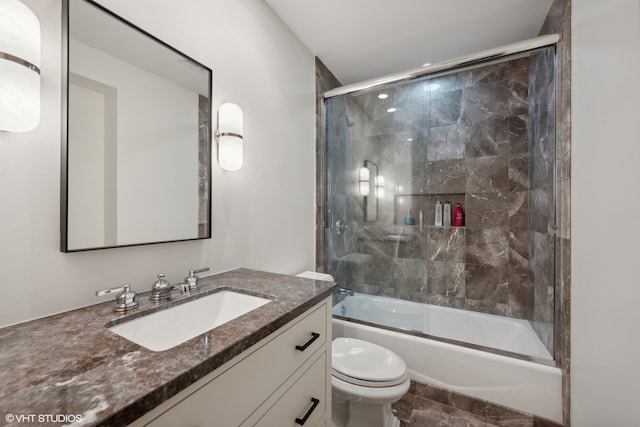 full bathroom featuring toilet, bath / shower combo with glass door, vanity, and tile flooring