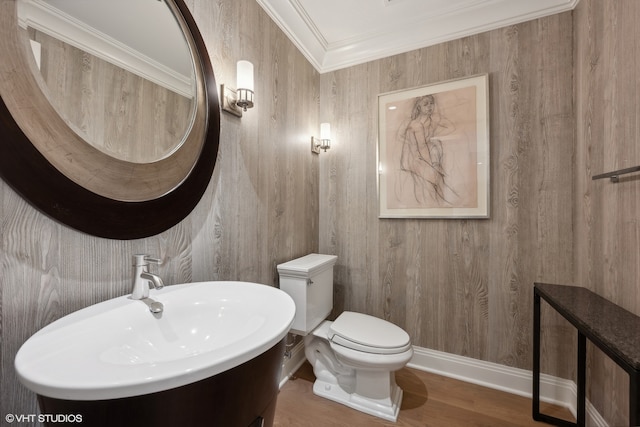 bathroom featuring wood walls, toilet, vanity, hardwood / wood-style floors, and ornamental molding