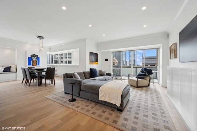 living room with crown molding, light hardwood / wood-style floors, and a notable chandelier