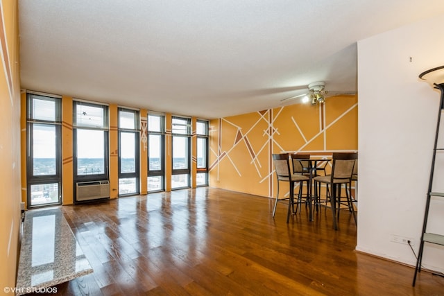 interior space with ceiling fan, expansive windows, dark hardwood / wood-style floors, and a textured ceiling