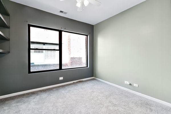 carpeted spare room with ceiling fan