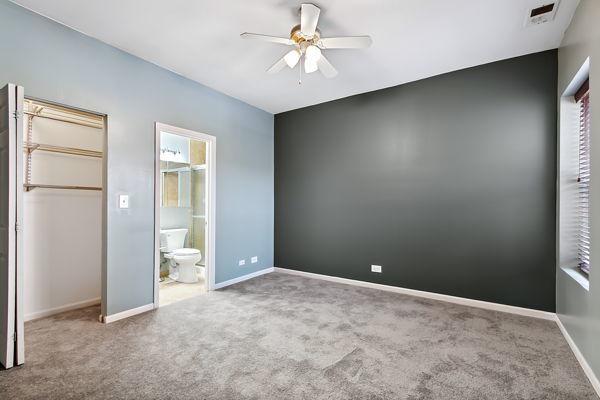 unfurnished bedroom featuring ceiling fan, ensuite bathroom, carpet flooring, and a closet