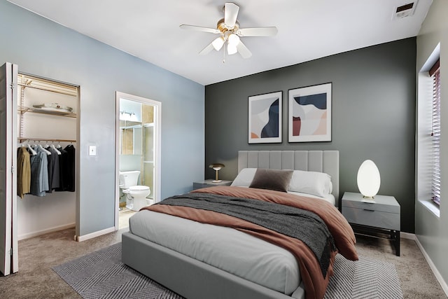 carpeted bedroom with multiple windows, a spacious closet, ceiling fan, ensuite bath, and a closet