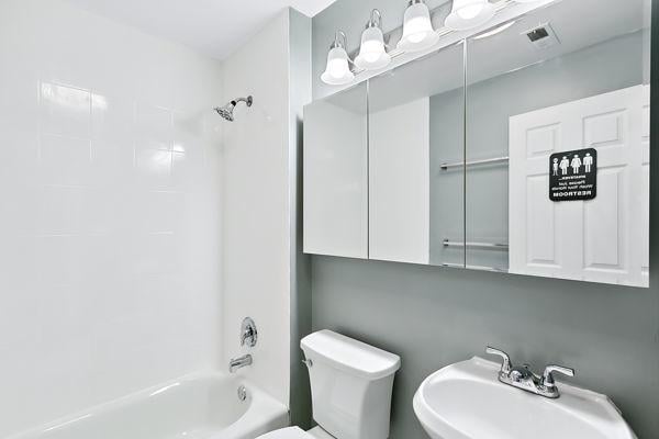 full bathroom featuring sink,  shower combination, and toilet