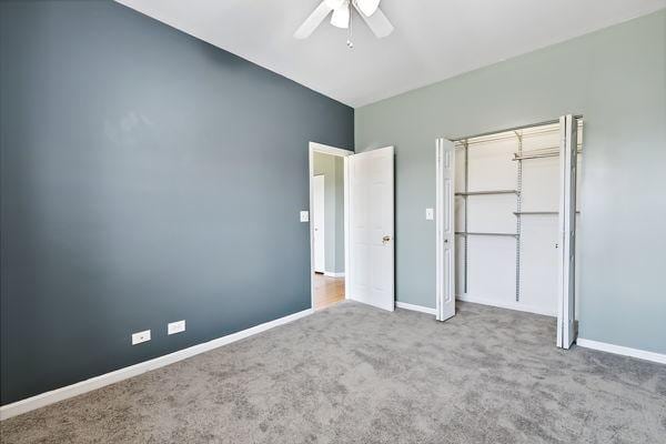 unfurnished bedroom featuring ceiling fan and carpet flooring