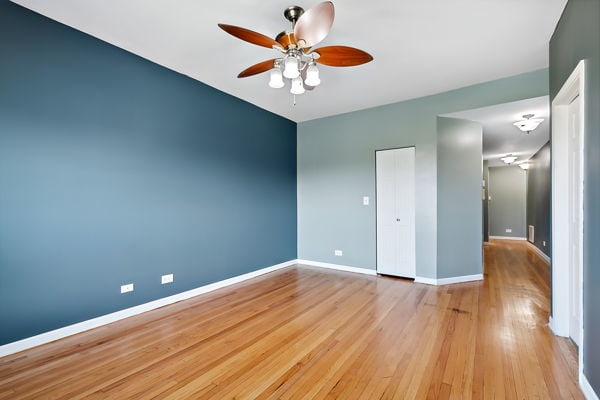 unfurnished bedroom featuring ceiling fan, a closet, and light hardwood / wood-style flooring