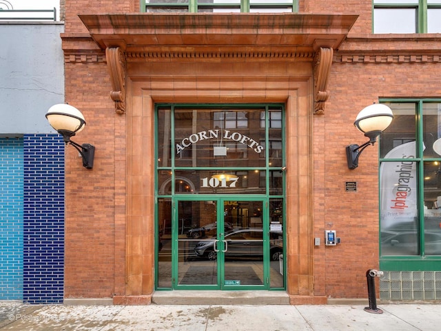 doorway to property with brick siding