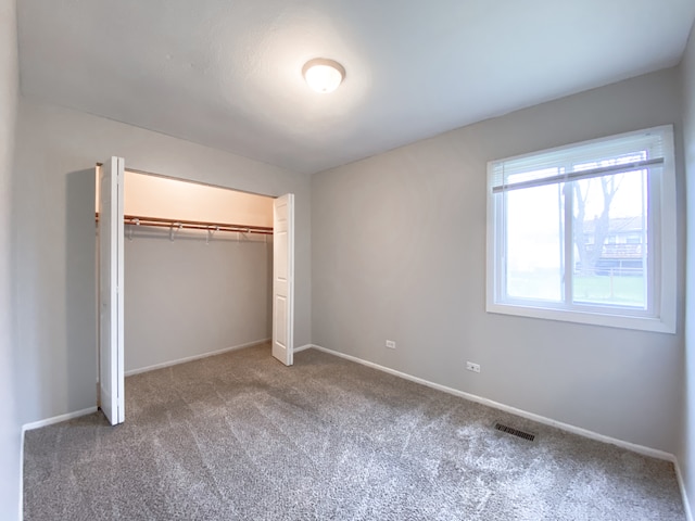 unfurnished bedroom with a closet and carpet flooring