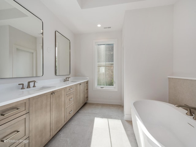 bathroom featuring vanity, tile patterned flooring, and a washtub