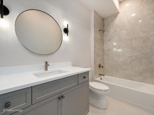 full bathroom featuring tile patterned floors, toilet, tiled shower / bath combo, and vanity