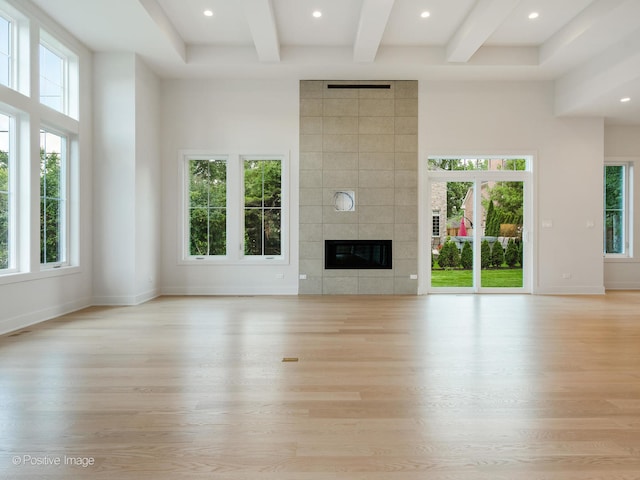 unfurnished living room featuring a fireplace, tile walls, and light hardwood / wood-style floors