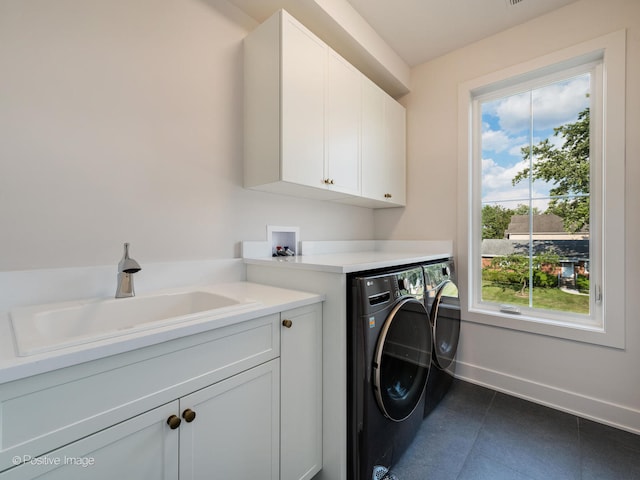 laundry room with tile patterned flooring, sink, cabinets, and separate washer and dryer