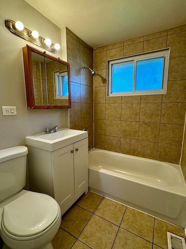 full bathroom featuring tiled shower / bath combo, vanity, tile floors, and toilet