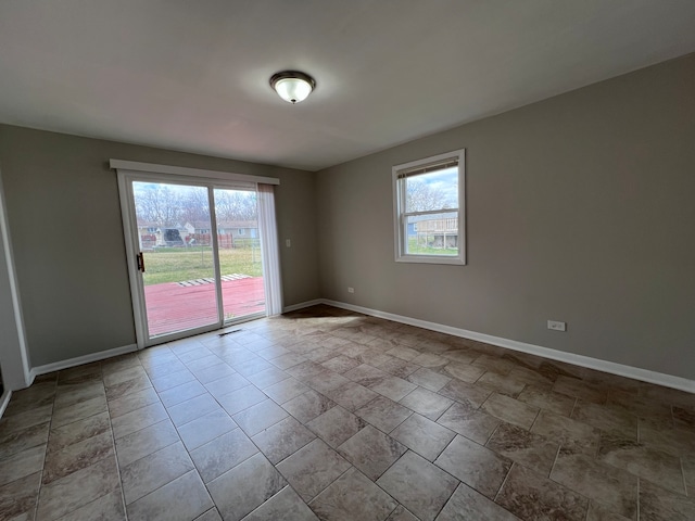 tiled empty room featuring a wealth of natural light