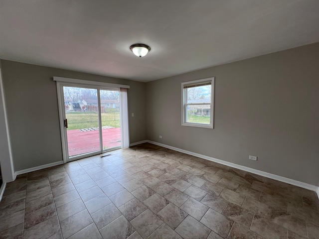 tiled spare room featuring a healthy amount of sunlight