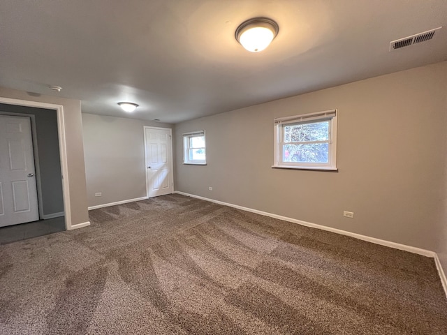 spare room with dark carpet