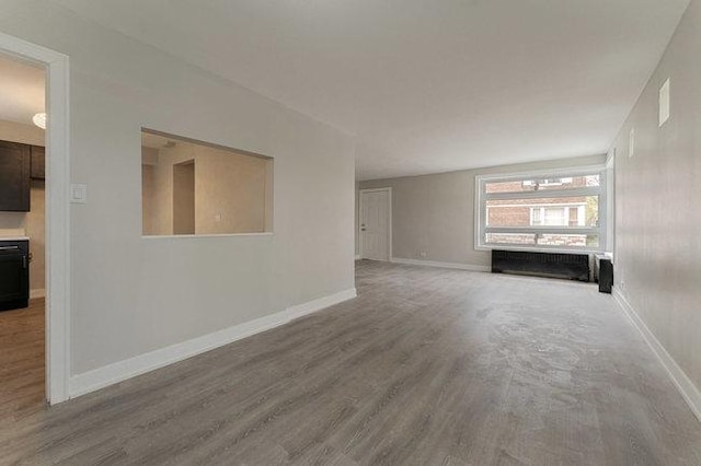 unfurnished living room with baseboards and wood finished floors