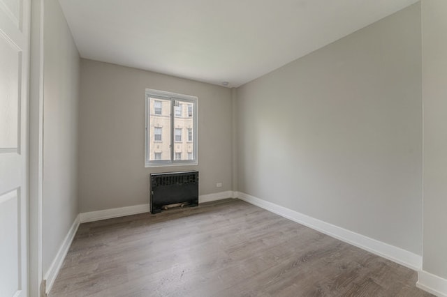 spare room with hardwood / wood-style flooring and radiator heating unit