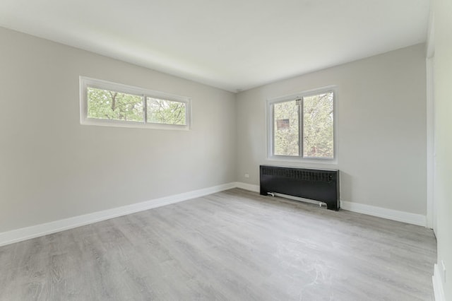 unfurnished living room with light hardwood / wood-style flooring and radiator