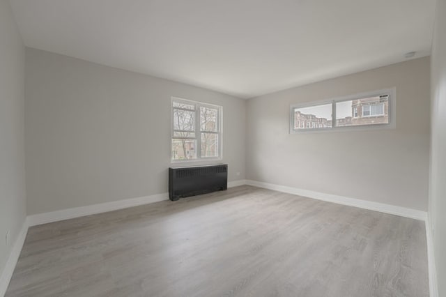 unfurnished room with wood-type flooring and radiator