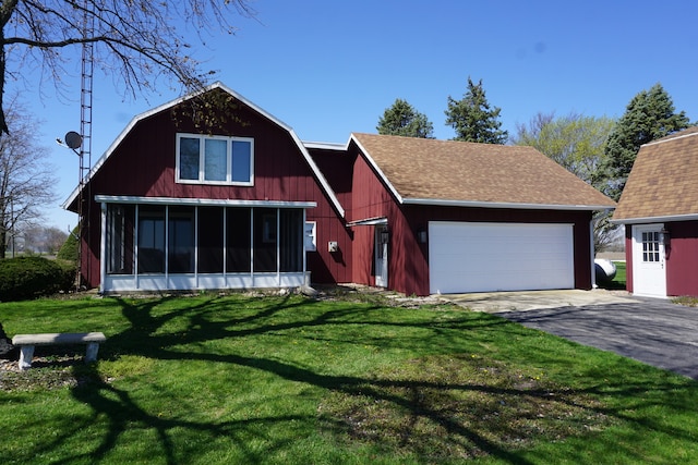 view of front of property with a sunroom, a garage, and a front lawn