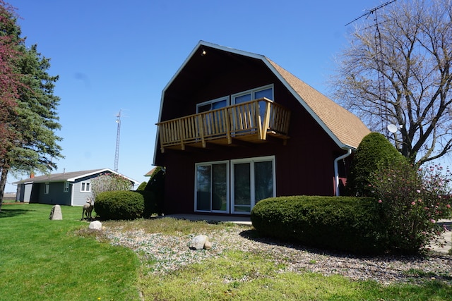 back of property with a balcony and a yard