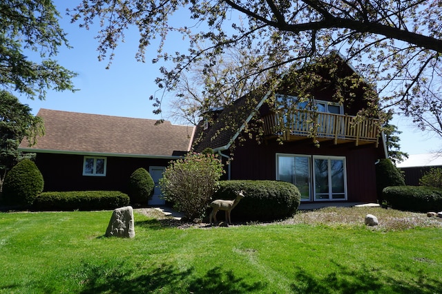 view of front of property featuring a balcony and a front yard