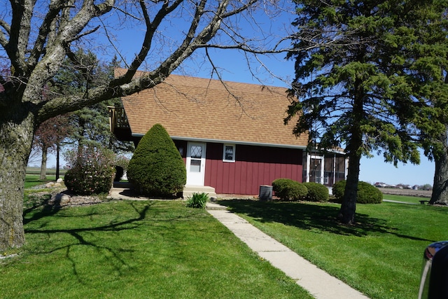 view of front of house featuring central AC unit and a front yard