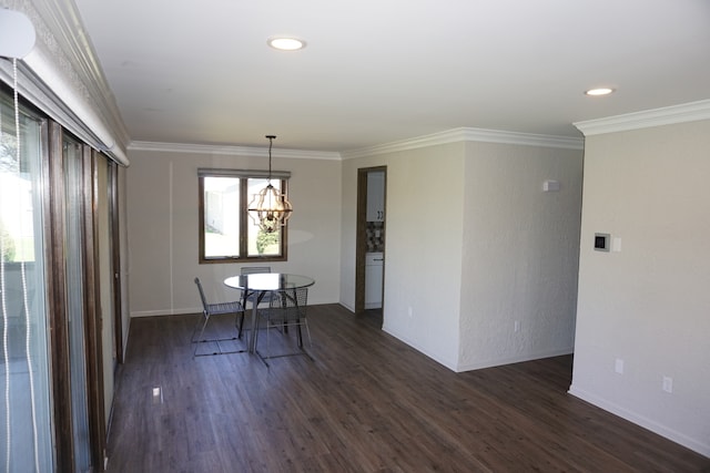 unfurnished dining area featuring ornamental molding, dark wood-type flooring, and a chandelier