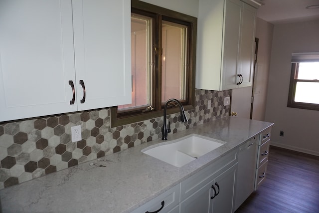 kitchen featuring tasteful backsplash, light stone countertops, and white cabinetry