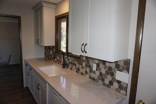 kitchen with backsplash, dark hardwood / wood-style flooring, sink, and light stone countertops