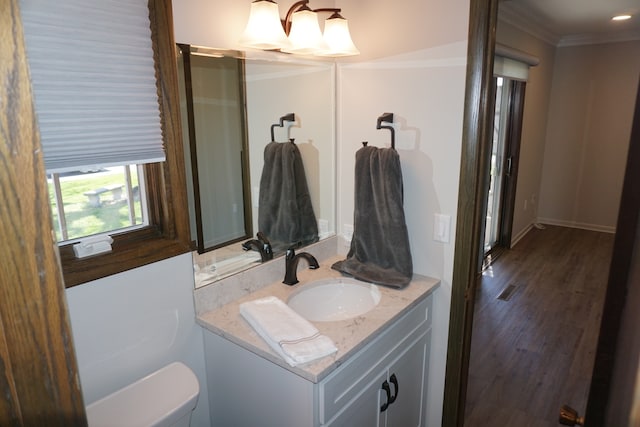 bathroom featuring hardwood / wood-style floors, oversized vanity, crown molding, and toilet