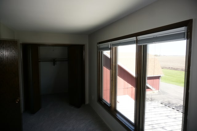 unfurnished bedroom featuring a closet and dark colored carpet