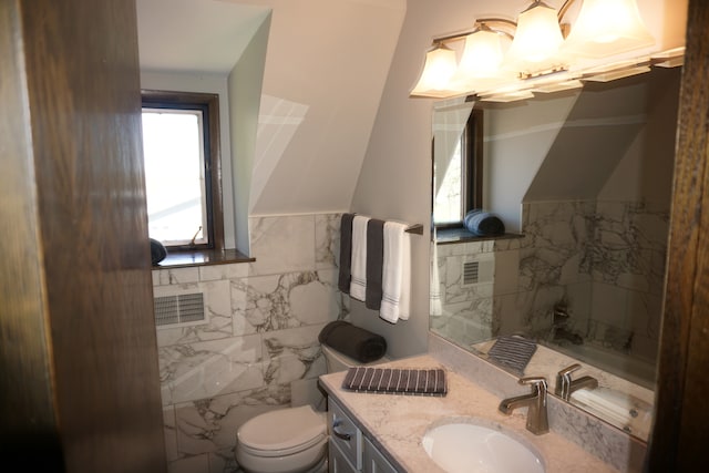 bathroom featuring tile walls, vanity, and toilet