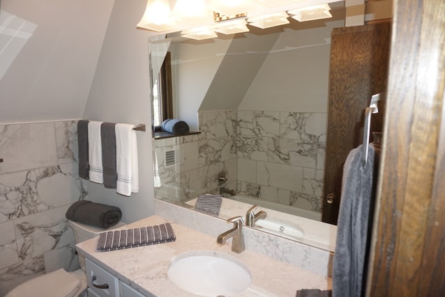 bathroom with tile walls, toilet, and vanity