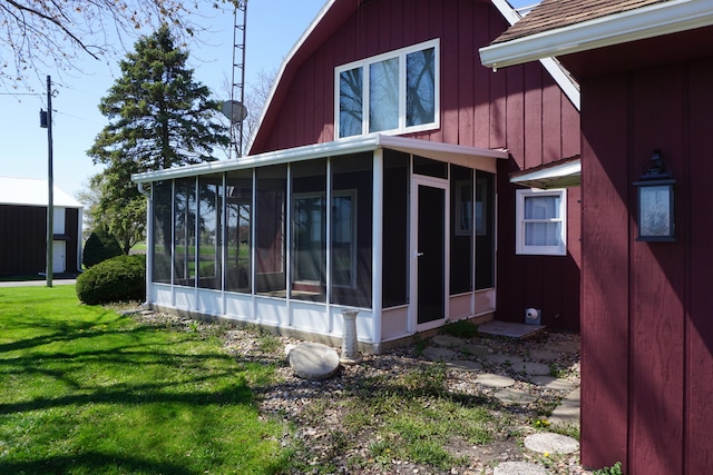 view of side of home featuring a sunroom and a lawn