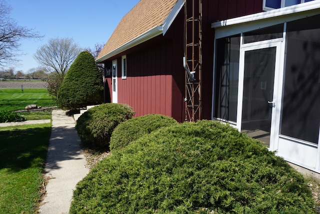 view of home's exterior featuring a yard and a sunroom