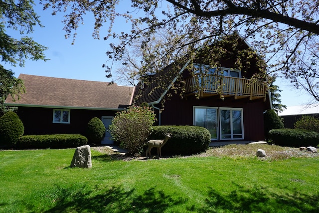 view of front of home featuring a balcony and a front lawn