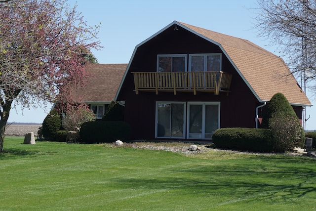 view of front of property with a balcony and a front lawn