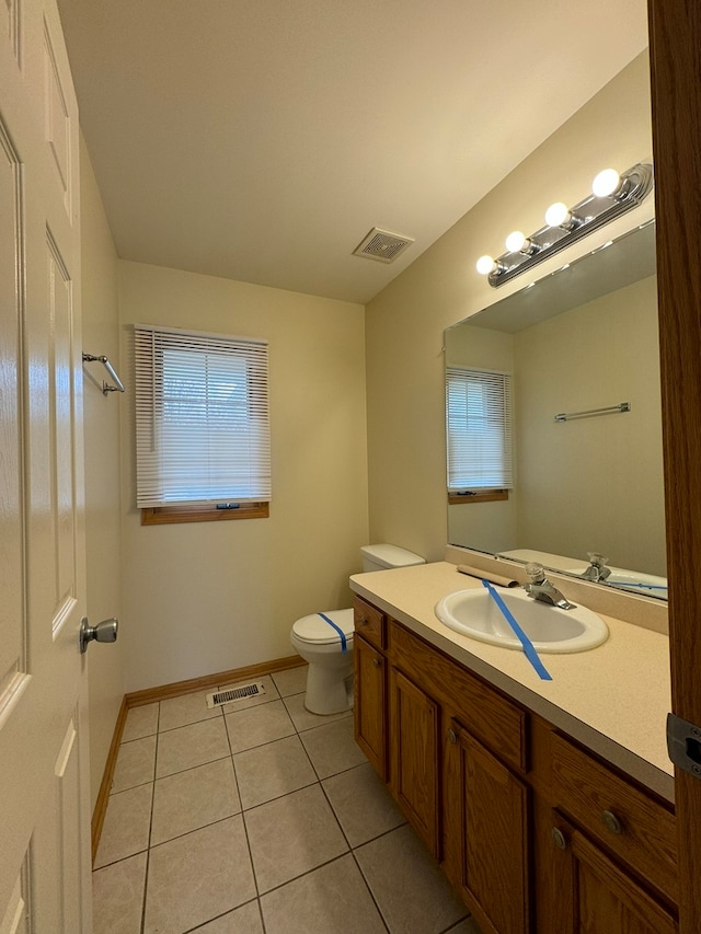 bathroom featuring toilet, tile flooring, and vanity