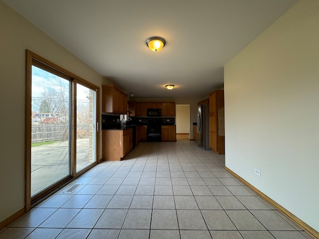 kitchen with sink, stainless steel fridge, light tile floors, and range