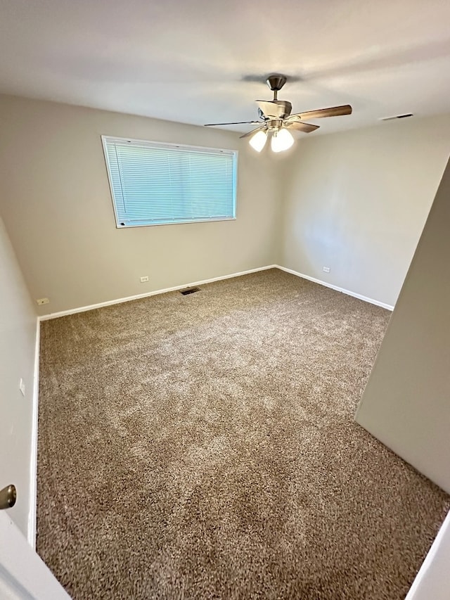 carpeted spare room with ceiling fan