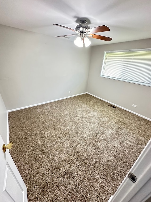 carpeted spare room featuring ceiling fan