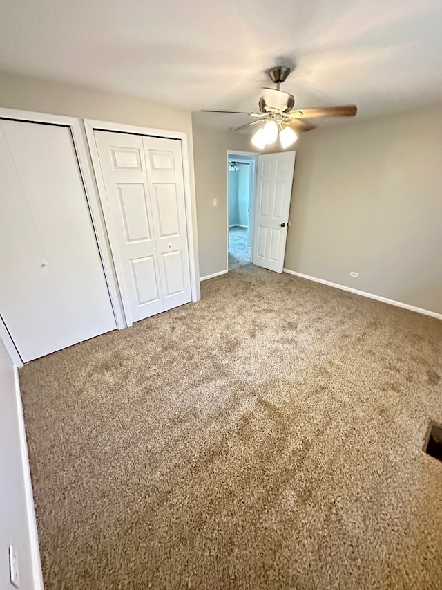 unfurnished bedroom with two closets, ceiling fan, and carpet