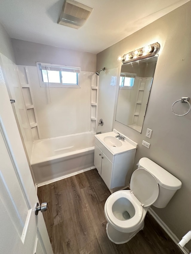 full bathroom with plenty of natural light, bathtub / shower combination, hardwood / wood-style flooring, and toilet