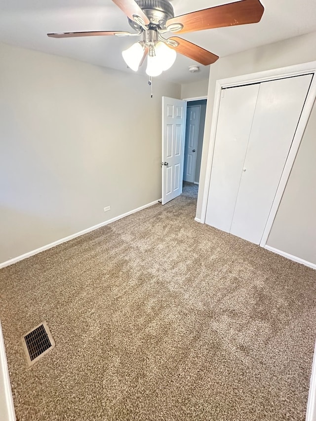 unfurnished bedroom with a closet, ceiling fan, and carpet flooring