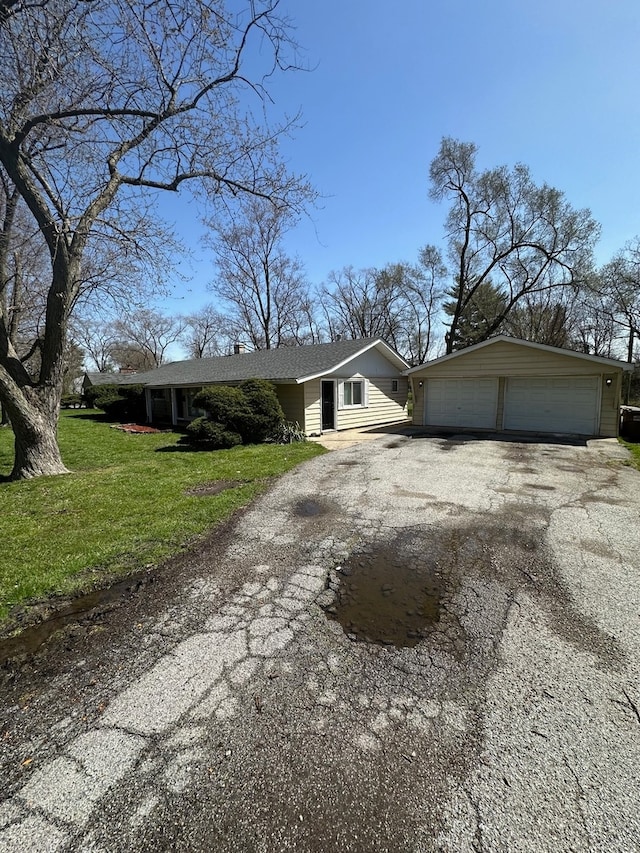 view of front facade featuring an outdoor structure, a front lawn, and a garage