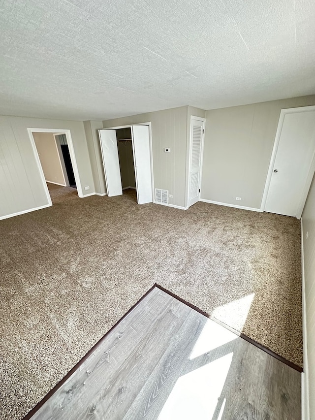 unfurnished bedroom featuring a textured ceiling and carpet floors