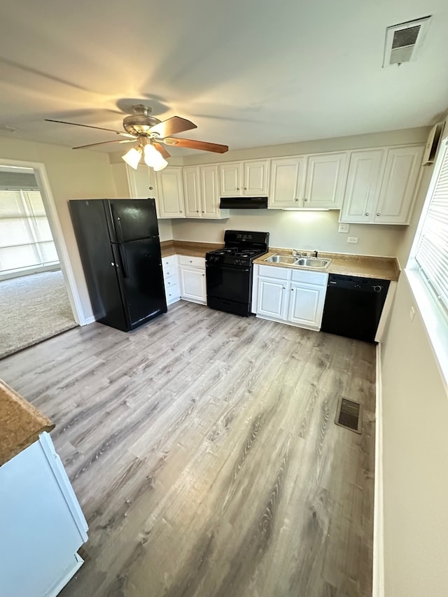 kitchen with ceiling fan, sink, light hardwood / wood-style floors, white cabinetry, and black appliances